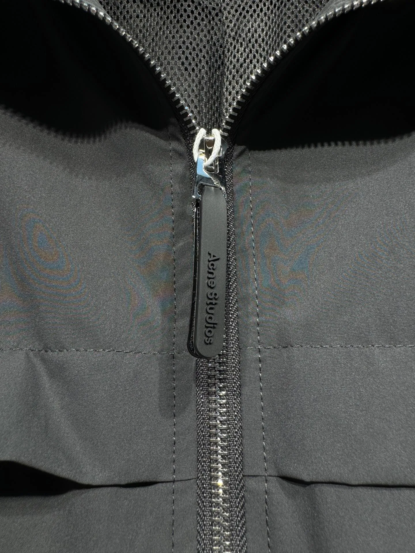 Acne Studios 26SS Large Lapel Short Jacket The fabric is made of 100% nylon (nylon/polyamide fiber) 75D high-density wrinkled nylon. The fabric has been permanently pressed and shaped by high temperature, and washed with high-pressure wrinkles at the factory to form its own irregular texture, permanently retaining the wrinkled texture, which will not disappear after washing. Matte matte coating removes the plastic glossy surface of nylon itself to create a low-key matte paper feel. Three-proof micro-coating, weak waterproof, anti-fouling, anti-static treatment, not easy to get dust. The interior is made of full-width mesh Breathable nylon lining, which reduces the stickiness of the nylon fabric to the body, improves air circulation, prevents sweating from sticking to the skin, and the zipper does not rub against the skin. The version adopts the raglan split topstitching process, and the front and rear panels are divided diagonally to expose even stitching. The three-dimensional dropped shoulders are loose and the fit is increased to increase the margin of movement. The back neckline is three-dimensional and high-density computer embroidered, and the embroidery lines are dense and not prickly. Customized all-metal matte nylon zipper, Genuine Leather embossed brand letters on the zipper leather tab, zipper tape with same color nylon fit to the body, double-locked reinforcement on both sides of the zipper to prevent pulling and tearing. Color: Gray Size: S M L